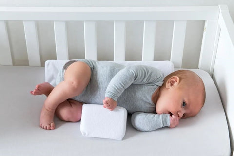 Baby sleeping securely with the Anti-Roll Wedge Pillow