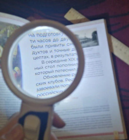 Person using Optical Magnifying Glass to read