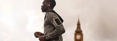 Person wearing ear clip bone conduction headphones in an office environment.